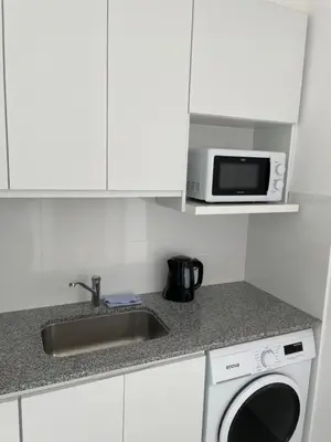a kitchen with a sink and a microwave at Departamento céntrico y espacioso en Río Cuarto. in Río Cuarto