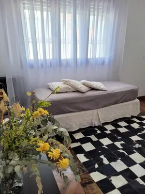 a bedroom with a bed with a window and flowers at Departamento céntrico y espacioso en Río Cuarto. in Río Cuarto