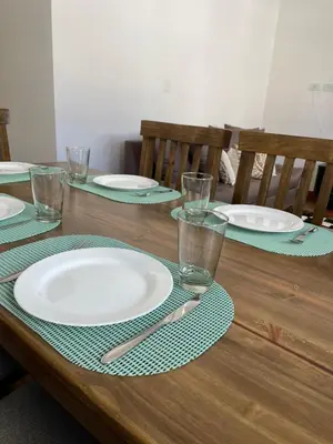 a wooden table with plates and glasses on it at Departamento céntrico y espacioso en Río Cuarto. in Río Cuarto