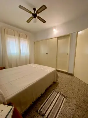 a bedroom with a bed and a ceiling fan at La Casita de la Villa in Villa Carlos Paz
