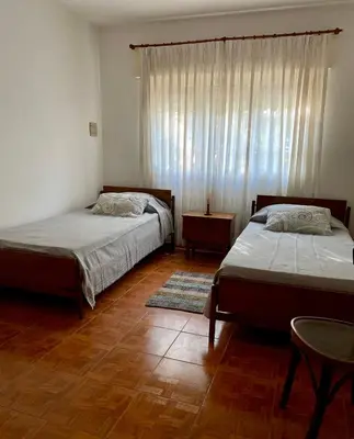 a bedroom with two beds and a window at La Casita de la Villa in Villa Carlos Paz