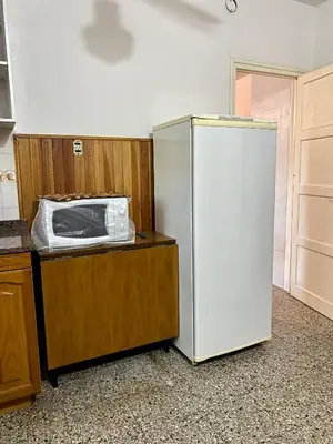 a kitchen with a white refrigerator and a microwave at La Casita de la Villa in Villa Carlos Paz