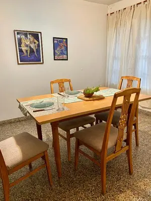 a wooden dining room table with four chairs and a table at La Casita de la Villa in Villa Carlos Paz