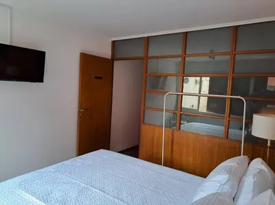 a bedroom with a bed and a large wooden cabinet at Departamento de lujo en Cordoba Capital in Cordoba