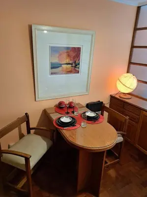 a wooden table with two chairs and a table with drinks on it at Departamento de lujo en Cordoba Capital in Cordoba