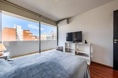 a bedroom with a large window and a tv at Lima 823 B General Paz in Cordoba