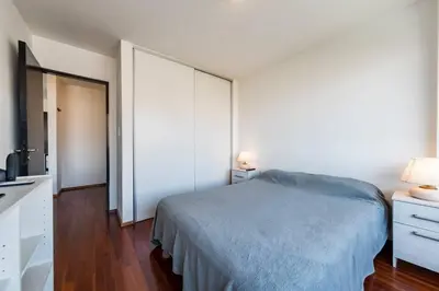 a white bedroom with a bed and a dresser and a mirror at Lima 823 B General Paz in Cordoba