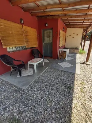 a red building with two chairs and a door at Cielos Abiertos in La Paz