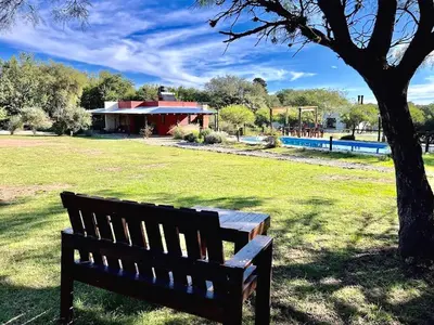 a park bench sitting under a tree in a field at Cielos Abiertos in La Paz
