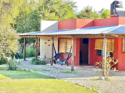 a red house with a hammock in front of it at Cielos Abiertos in La Paz