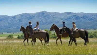 a group of people riding horses in a field at Cielos Abiertos in La Paz