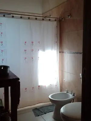 a bathroom with a sink and a toilet and a window at Cabaña en Villa Amancay in Villa Amancay
