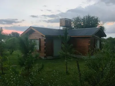a small wooden house in a field with at Cabaña en Villa Amancay in Villa Amancay