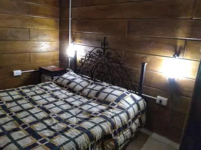a bedroom with a bed with two lights on it at Cabaña en Villa Amancay in Villa Amancay