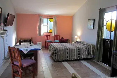 a bedroom with a bed and a table and chairs at LUNA CAUTIVA in Santa Rosa de Calamuchita