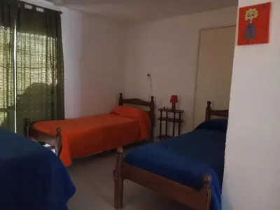 a bedroom with two beds and a window at LUNA CAUTIVA in Santa Rosa de Calamuchita