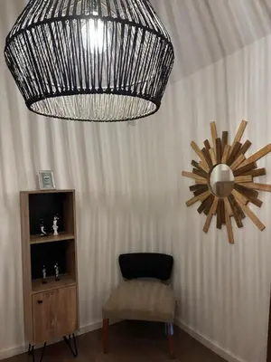 a room with a chandelier and a chair and a mirror at Depto 23 en Barrio Villa Belgrano excelente ubicación in Cordoba