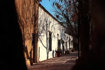 an alley way with a shadow of a building at Cabañas LAS REARTENSES in Los Reartes