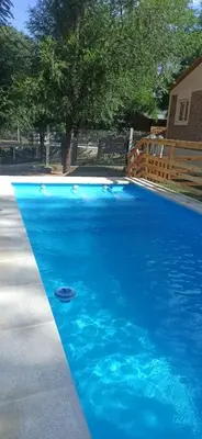 a blue swimming pool with a frisbee in it at Cabañas LAS REARTENSES in Los Reartes