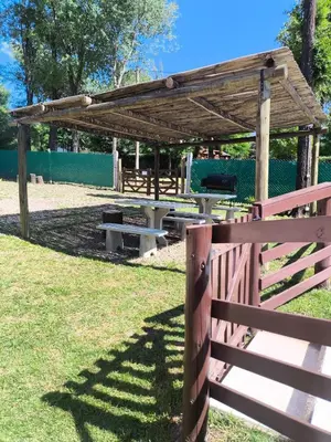 a picnic shelter with a fence and a picnic table at Cabañas LAS REARTENSES in Los Reartes