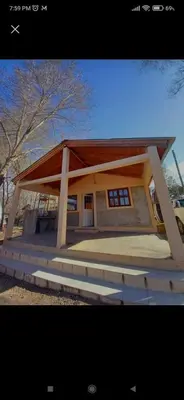 a small house with a large roof at Cabañas LAS REARTENSES in Los Reartes