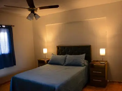 a bedroom with a bed with two night stands and two lamps at Potrero de Garay in Potrero de Garay