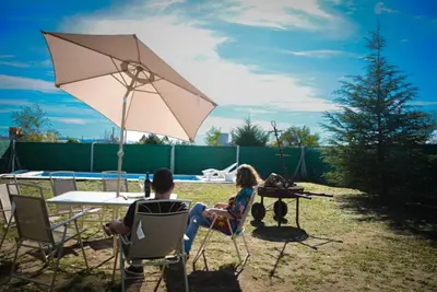 a man and woman sitting at a table with an umbrella at Potrero de Garay in Potrero de Garay