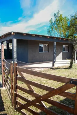 a house with a wooden fence in front of it at Potrero de Garay in Potrero de Garay