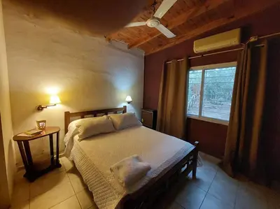a bedroom with a large bed and a window at Cardozo House, casa de campo in Villa Dolores