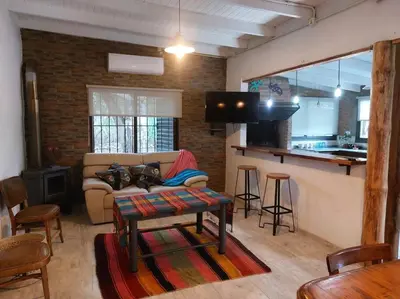 a living room with a couch and a kitchen at Cardozo House, casa de campo in Villa Dolores