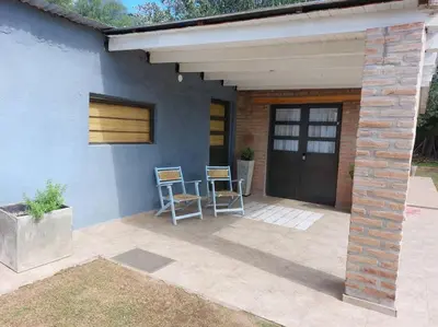 a patio with two chairs next to a house at Cardozo House, casa de campo in Villa Dolores