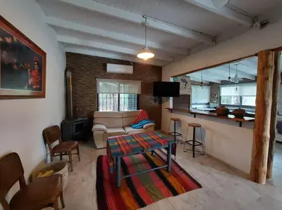 a living room with a couch and a table at Cardozo House, casa de campo in Villa Dolores