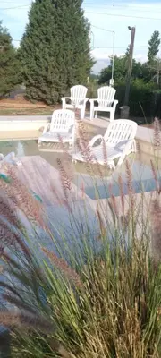 a group of white chairs sitting next to a pool at Cardozo House, casa de campo in Villa Dolores