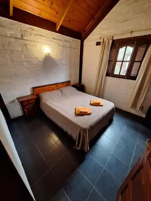 a bedroom with a bed with two towels on it at Los Moradillos Cabañas in Santa Rosa de Calamuchita