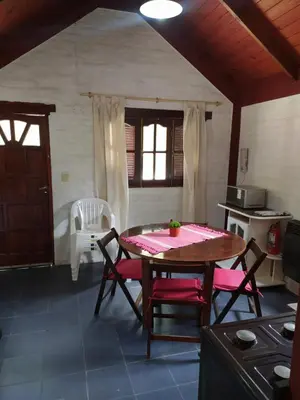a kitchen with a table and chairs in a room at Los Moradillos Cabañas in Santa Rosa de Calamuchita