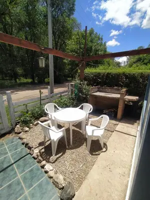 a patio with a white table and two chairs at Los Moradillos Cabañas in Santa Rosa de Calamuchita