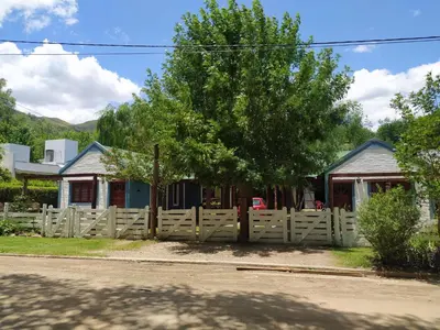 a wooden fence in front of a house at Los Moradillos Cabañas in Santa Rosa de Calamuchita