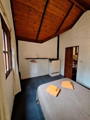 a bedroom with a bed with two towels on it at Los Moradillos Cabañas in Santa Rosa de Calamuchita