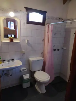 a bathroom with a toilet and a sink at Los Moradillos Cabañas in Santa Rosa de Calamuchita