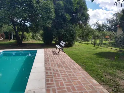 a bench sitting on a brick walkway next to a swimming pool at Cabañas Matilda in Los Molles