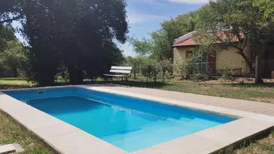 a swimming pool in a yard with a bench at Cabañas Matilda in Los Molles