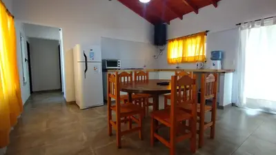 a kitchen with a table and chairs and a refrigerator at Cabañas Matilda in Los Molles