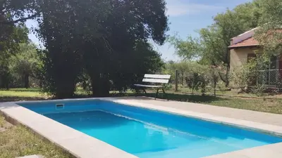 a bench sitting next to a blue swimming pool at Cabañas Matilda in Los Molles