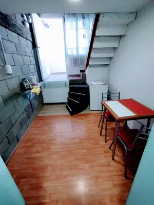 a room with a table and chairs and stairs at Duplex-Loft in Cordoba