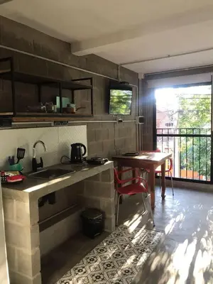 a kitchen with a sink and a table at Departamento pleno centro costanera estilo industrial único in Santa Rosa de Calamuchita