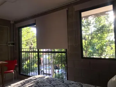 a bedroom with a bed and a window with a balcony at Departamento pleno centro costanera estilo industrial único in Santa Rosa de Calamuchita