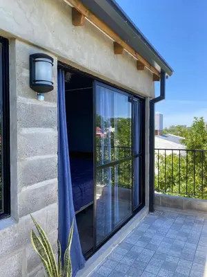 a sliding glass door on a house with a balcony at Departamento pleno centro costanera estilo industrial único in Santa Rosa de Calamuchita
