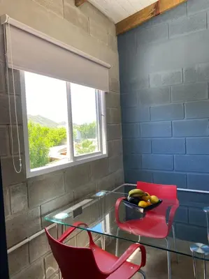 a room with a glass table and two red chairs at Departamento pleno centro costanera estilo industrial único in Santa Rosa de Calamuchita
