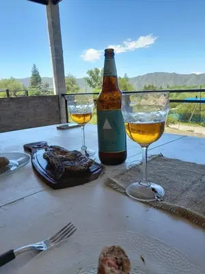 a table with two glasses and a bottle of wine at CHALET DE SIQUIMAN in Villa Parque Siquiman