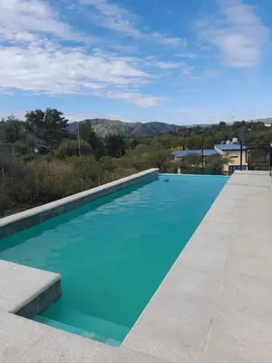 a blue swimming pool with a view of the mountains at CHALET DE SIQUIMAN in Villa Parque Siquiman